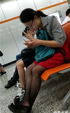 街拍黑丝眼镜妹，玩手机真入迷