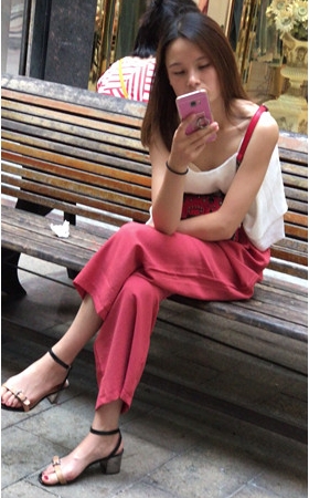 路边玩手机的小妹