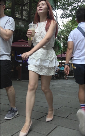 喝着奶茶的白色连体裙美女