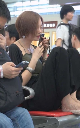 候车室的美女把脚放在板凳上