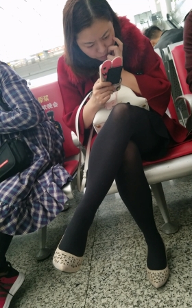 高铁站候车大厅等车的黑色丝袜美腿少妇
