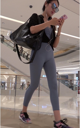 商场里戴着墨镜的紧身裤美女