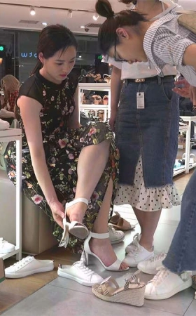 美脚女孩在鞋店试鞋子的场景