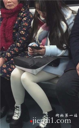 低头玩手机的白丝袜美腿可爱萌妹子。