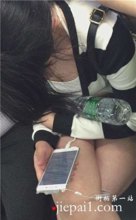 地铁上只顾着低头玩手机的女孩
