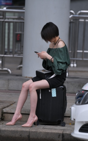 坐在箱子上等人的高跟美腿