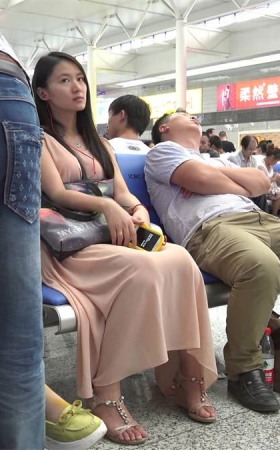 漂亮女孩就算坐姿再低调，在一群普通旅客中还是太醒目了