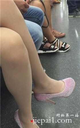 地铁上低头玩手机的女孩，一双高跟很抢眼。