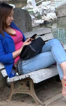 丰满紧身蓝牛高跟鞋美女公园石凳上玩手机