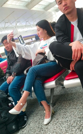 火车上拍照的高跟牛仔裤美女
