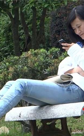 紧身蓝牛美眉石凳上玩手机晾脚