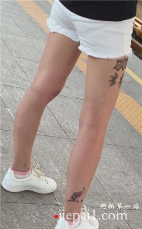 大腿上满是纹身的狂野妹子，白腿热裤板鞋好身材。