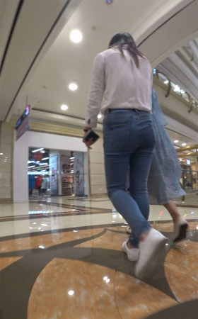 白衬衫紧身蓝色牛仔裤街拍美女跟姐妹逛商场