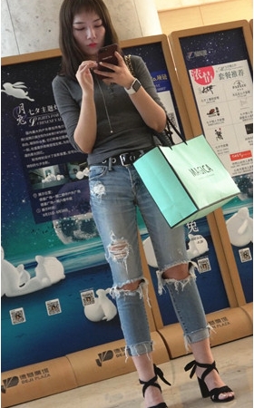 玩手机的破洞牛仔裤妹子