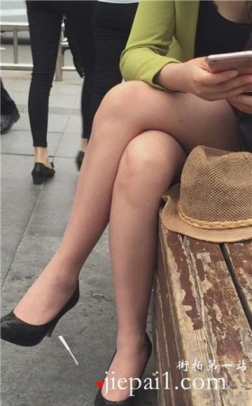 街拍性感高跟短裙美腿美女花坛边休息。
